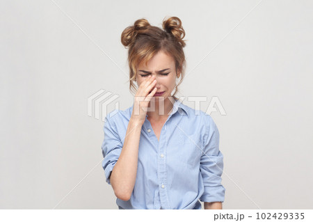 Portrait of displeased upset blonde woman frowning face, crying, being discontent and unhappy as cant achieve goals, wearing blue shirt. Indoor studio shot isolated on gray background. 102429335