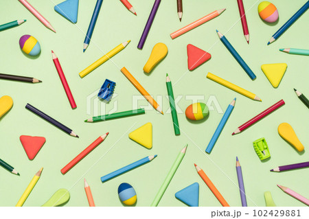 Colored Pencils and rubber erasers background pattern on light green. Back to School or drawing and creativity concept. Copy space in center. Top view Colored Pencils and rubber erasers background pattern on light green. Back to School or drawing and creativity concept. Copy space in center. Top view 102429881
