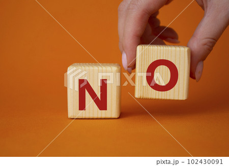 No symbol. Concept words No on wooden blocks. Businessman hand. Beautiful orange background. Business and No concept. Copy space. 102430091