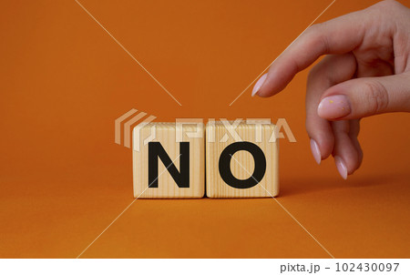No symbol. Concept words No on wooden blocks. Businessman hand. Beautiful orange background. Business and No concept. Copy space. 102430097