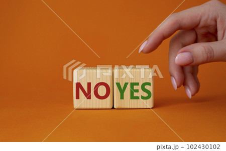 Yes vs No symbol. Businessman hand is making a choice between YES and No symbol. Beautiful orange background. Business concept. Copy space. Yes vs No symbol. Businessman hand is making a choice between YES and No symbol. Beautiful orange background. Business concept. Copy space. 102430102
