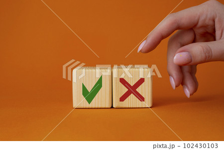 Yes vs No symbol. Businessman hand is making a choice between YES and No symbol. Beautiful orange background. Business concept. Copy space. 102430103