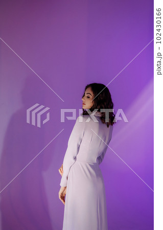 Young woman in a tight dress on a purple background Young woman in a tight dress on a purple background 102430166