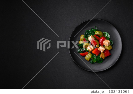 Delicious fresh salad of zucchini, cheese, sweet peppers, spinach with spices and herbs 102431062