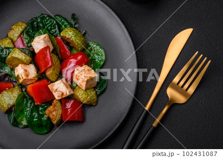 Delicious fresh salad of zucchini, cheese, sweet peppers, spinach with spices and herbs 102431087