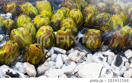 Artichokes being grilled on charcoal 102431168