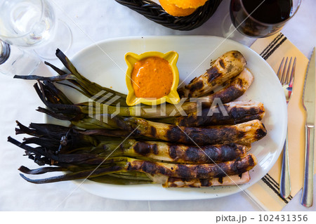 Top view of grilled calcots with romesco sauce 102431356