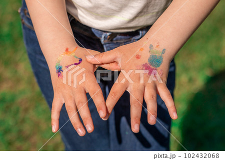 Shimmering sparkling glitter tattoo on a child's hand at a birthday party Shimmering sparkling glitter tattoo on a child's hand at a birthday party 102432068