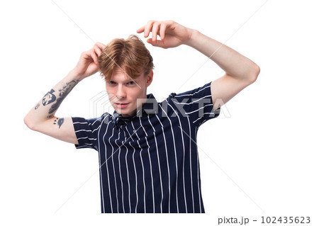 emotional positive 25 year old blond man with tattoos in a striped polo posing on a white background emotional positive 25 year old blond man with tattoos in a striped polo posing on a white background 102435623