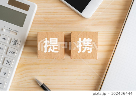 提携と書かれたブロック、電卓、スマホ、ノート、ペン 102436444