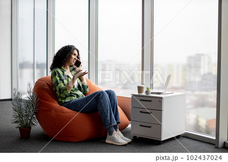 Lady having conversation on phone with coworkers indoors 102437024