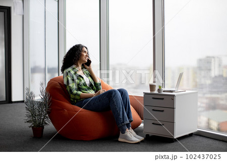 Lady having conversation on phone with coworkers indoors 102437025