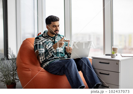 Handsome indian man gesturing hands while speaking on video 102437073