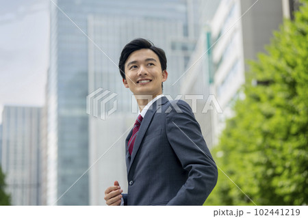 オフィス街に立つ若いビジネスマン ポートレート オフィス街に立つ若いビジネスマン ポートレート 102441219