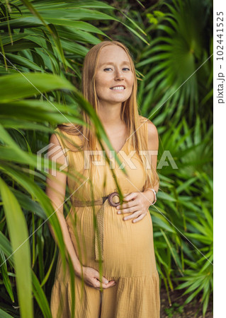Pregnant woman walks in park at evening. Family enjoying pregnancy. The concept of Mother's Day and Women's Day 102441525