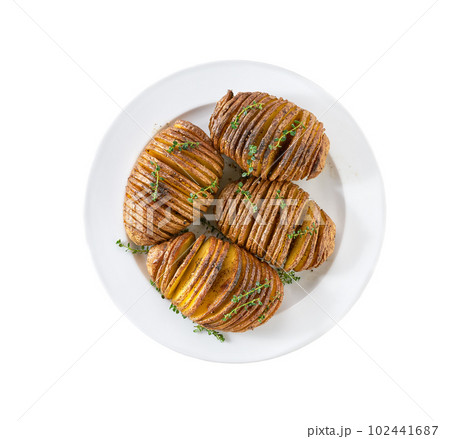 Crispy roasted hasselback potato in a plate isolated on white background. Crispy roasted hasselback potato in a plate isolated on white background. 102441687