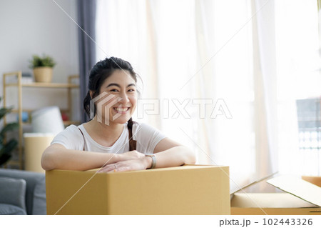 Happy woman smiling at home during move with boxes 102443326