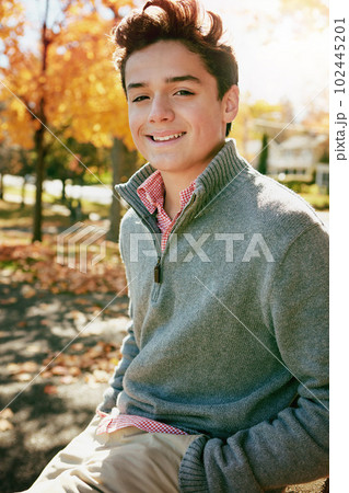 Its autumn and Im feeling chilled. Portrait of a happy teenage boy enjoying an autumn day in the park. 102445201