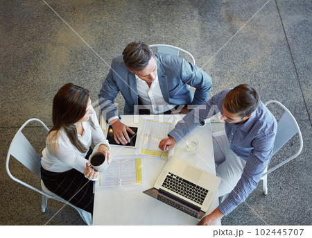 Working together. High angle shot of three businesspeople working in the office. 102445707