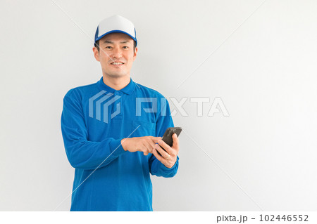 スマホアプリを使う引越し業者・配達員の男性（引越し・配達・軽貨物ドライバー・宅配・配達員・宅急便） 102446552