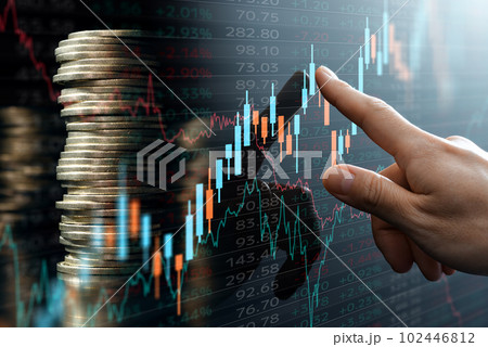 投資利益の増加のイメージ。積み上げたコインと金融市場のデータ。ローソク足チャートを指し示す手。 投資利益の増加のイメージ。積み上げたコインと金融市場のデータ。ローソク足チャートを指し示す手。 102446812