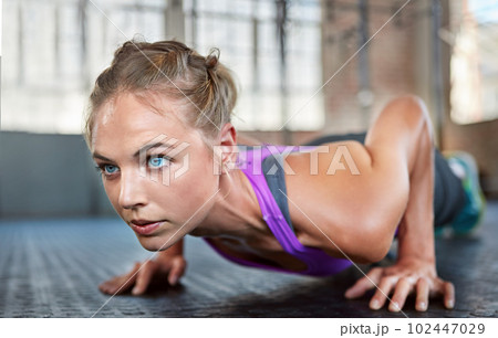 Pain is temporary but quitting lasts forever. a sporty young woman doing push-ups at the gym. Pain is temporary but quitting lasts forever. a sporty young woman doing push-ups at the gym. 102447029
