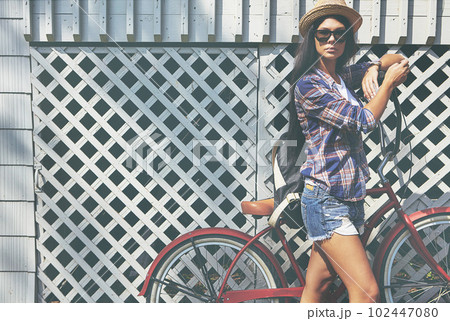 Enjoying a refreshing day out. Portrait of a beautiful young woman riding her bike in the park. Enjoying a refreshing day out. Portrait of a beautiful young woman riding her bike in the park. 102447080