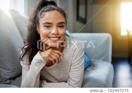 Bring on the weekend. Portrait of a smiling young woman relaxing on the sofa at home. Bring on the weekend. Portrait of a smiling young woman relaxing on the sofa at home. 102447275