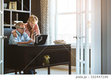 Getting their affairs in order. a mature woman keeping her husband company while he works from home. 102447286