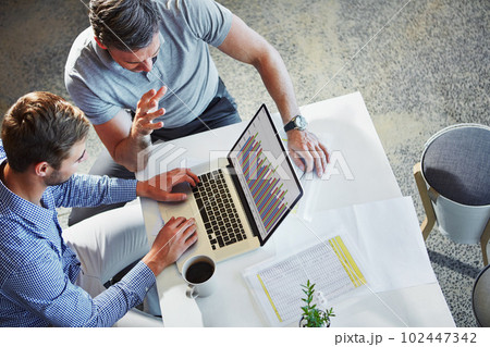 Charting business growth with technology. two colleagues using a laptop in a meeting at the office. 102447342