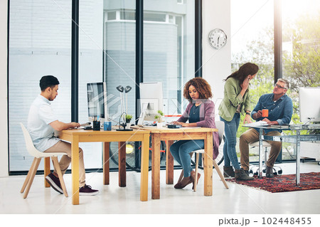Great things happen when creatives work together. group of creative colleagues working on a project together in their office. 102448455