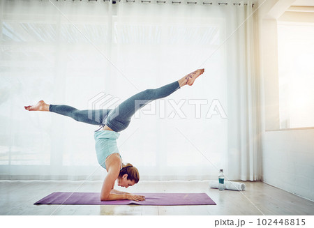 There isnt a care in the world floating through me. an attractive woman practising her yoga routine at home. 102448815