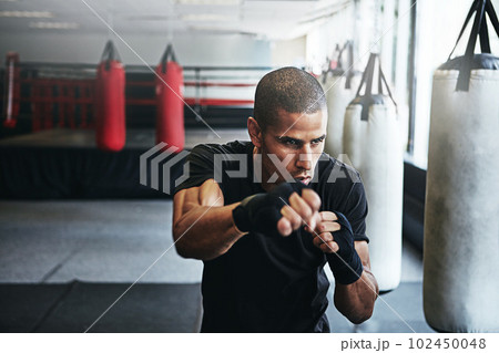 Mama raised a fighter. a kick-boxer training in a gym. Mama raised a fighter. a kick-boxer training in a gym. 102450048