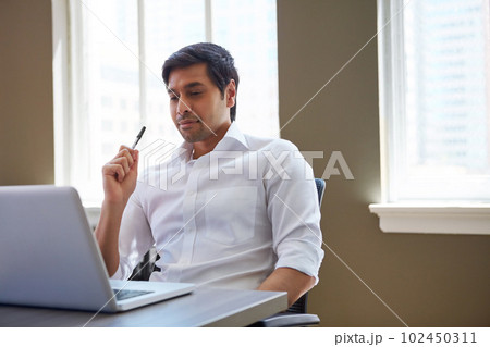 The master of his own success. a businessman working at his desk. The master of his own success. a businessman working at his desk. 102450311