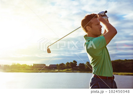 Living life swing by swing. a man practicing his swing on the golf course. Living life swing by swing. a man practicing his swing on the golf course. 102450348