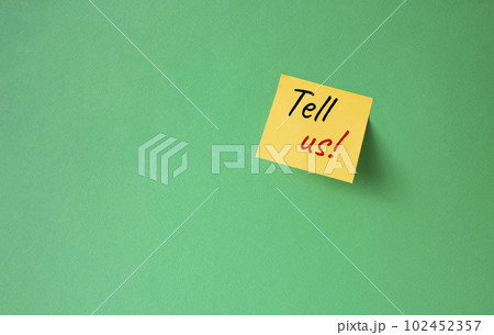 Tell us symbol. Orange steaky note with words Tell us. Beautiful green background. Business and Tell us concept. Copy space. Tell us symbol. Orange steaky note with words Tell us. Beautiful green background. Business and Tell us concept. Copy space. 102452357