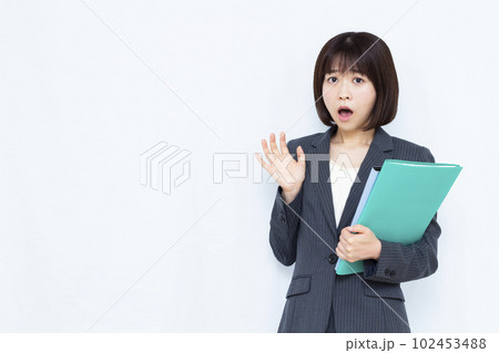 白い背景の前でびっくりしている30代のスーツ姿の女性 白い背景の前でびっくりしている30代のスーツ姿の女性 102453488