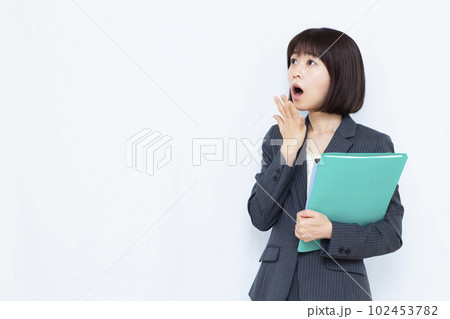 白い背景の前で驚いているスーツ姿の30代女性 白い背景の前で驚いているスーツ姿の30代女性 102453782