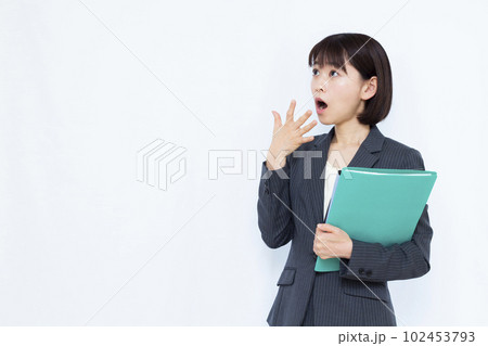 白い背景の前で驚いているスーツ姿の30代女性 102453793