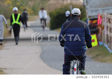 公園の遊歩道を走る自転車の男性 公園の遊歩道を走る自転車の男性 102456161