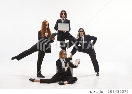 Portrait with group of charming woman, ballet dancer in classical suit working with gadgets on white background. Business partners 102459075