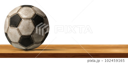 Old Soccer Ball on a Wooden Table Isolated on White Background. Old Soccer Ball on a Wooden Table Isolated on White Background. 102459165