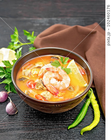 Soup Tom Yum with lemons in bowl on black board 102460176