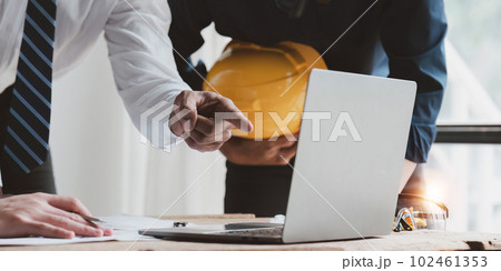 Architect team working with blueprints for architectural plan, engineer sketching a construction project, green energy concept Architect team working with blueprints for architectural plan, engineer sketching a construction project, green energy concept 102461353