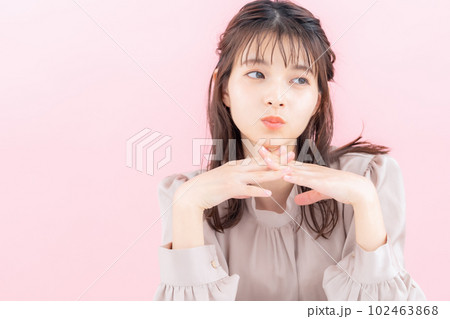 ピンクバックでスキンケアをする若い女性 102463868