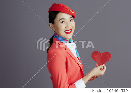 smiling stylish asian female air hostess against gray 102464539