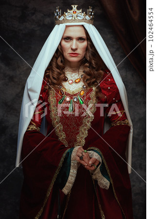 medieval queen in red dress with veil and crown 102464554