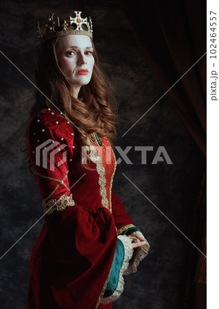 medieval queen in red dress with white makeup and crown medieval queen in red dress with white makeup and crown 102464557