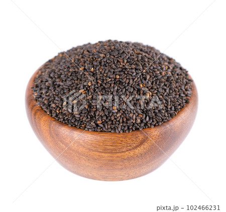 Basil seeds in wooden bowl, isolated on white background. Ocimum basilicum. 102466231