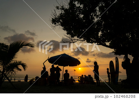 クタビーチの夕日と人々のシルエット クタビーチの夕日と人々のシルエット 102468208